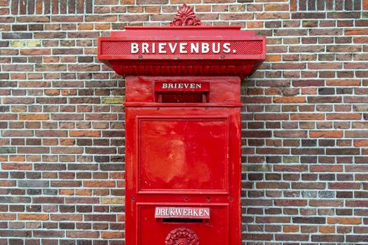 Brievenbus Uden in het centrum met winkels en straatbeeld rond de Markt op de achtergrond