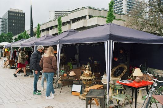 Bezoekers struinen langs kramen op een vlooienmarkt uden 2026 in een hal of evenemententerrein bij Uden