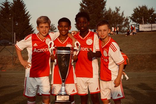 Supporters volgen ajax nieuws op een telefoon en tv tijdens een voetbalavond in Uden