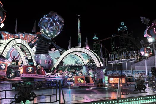 Kermis Uden 2026 attracties op een verlicht plein in het centrum met draaimolen, snackkramen en bezoekers
